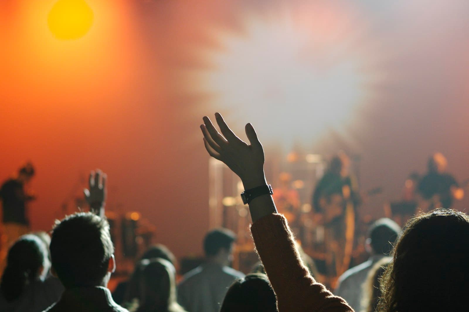 A congregation in worship, hands raised in warm light